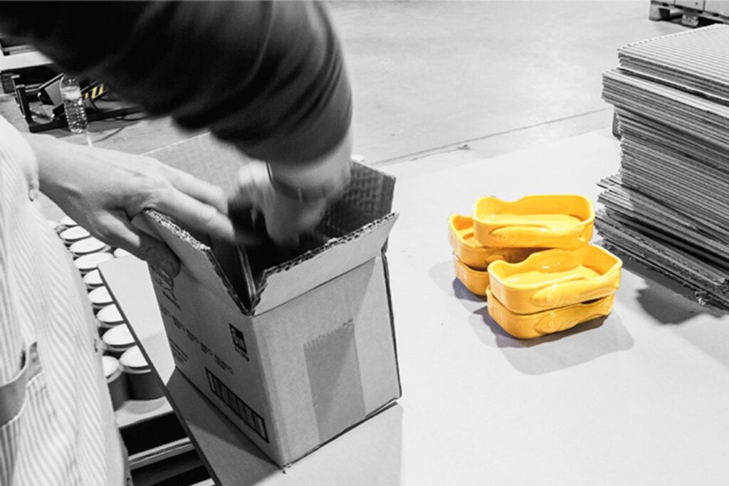 Embalamento manual de peças cerâmicas com destaque para recipientes amarelos