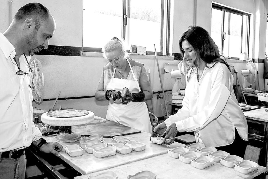 Produção artesanal de peças cerâmicas com equipa a trabalhar em bancada